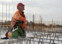 bouwplaats: kraanmachinist en breedplaatvloer leggen