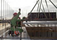 bouwplaats: kraanmachinist en breedplaatvloer leggen