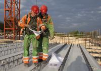 bouwplaats: kraanmachinist en breedplaatvloer leggen